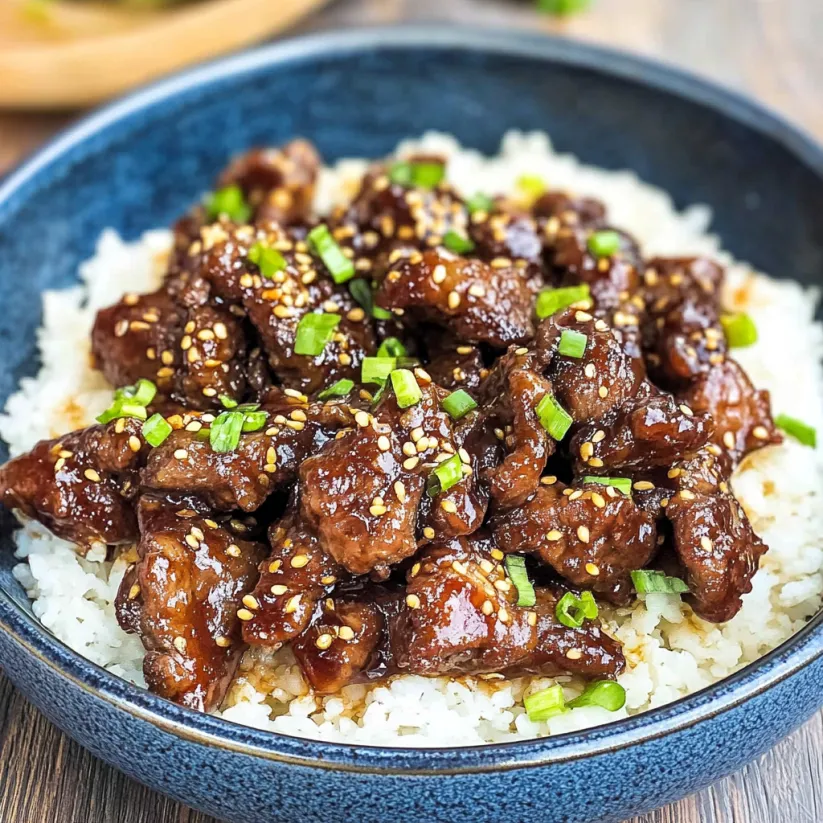 A bowl of crispy sticky beef with rice.