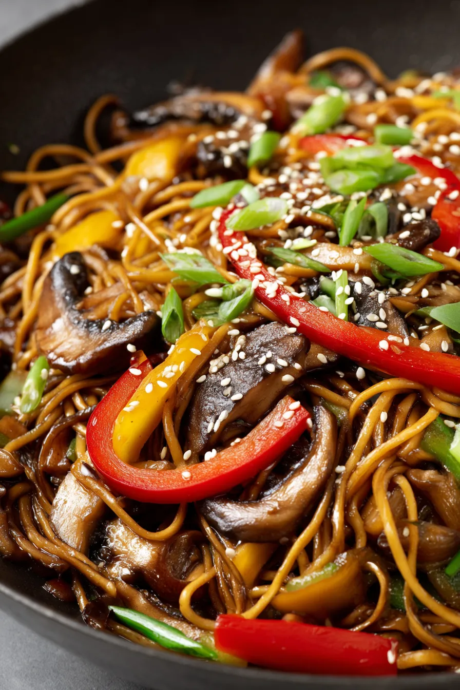 A plate of noodles with mushrooms and peppers.