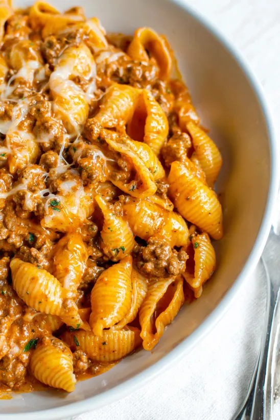 A bowl of pasta with meat and cheese.