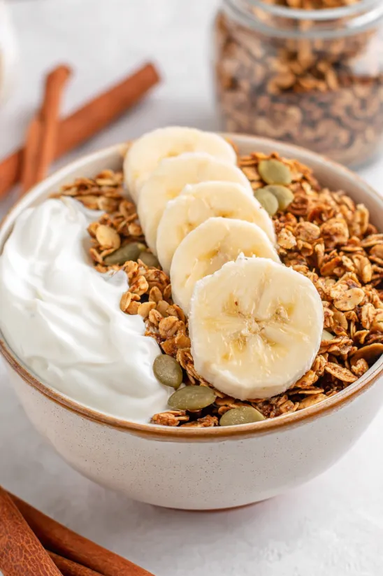 A bowl of cereal with bananas.