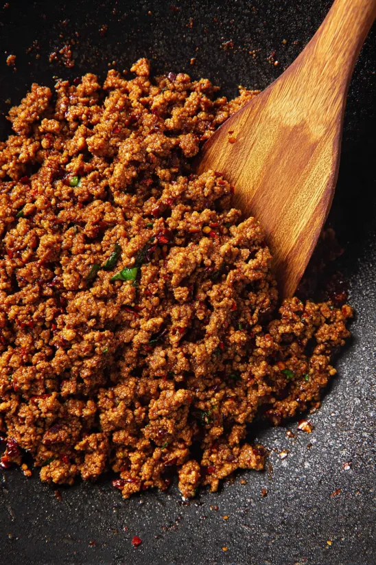 A wooden spoon is used to mix Mexican chorizo.