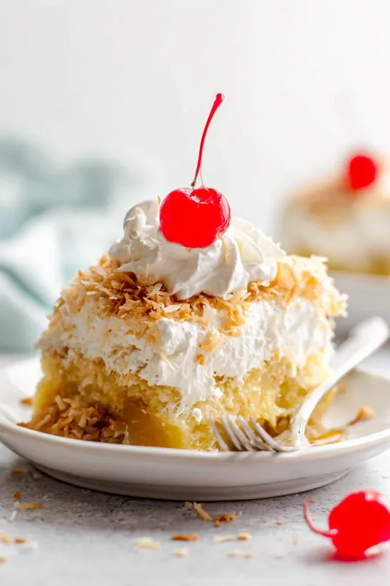 A slice of tropical twinkie cake with a cherry on top.