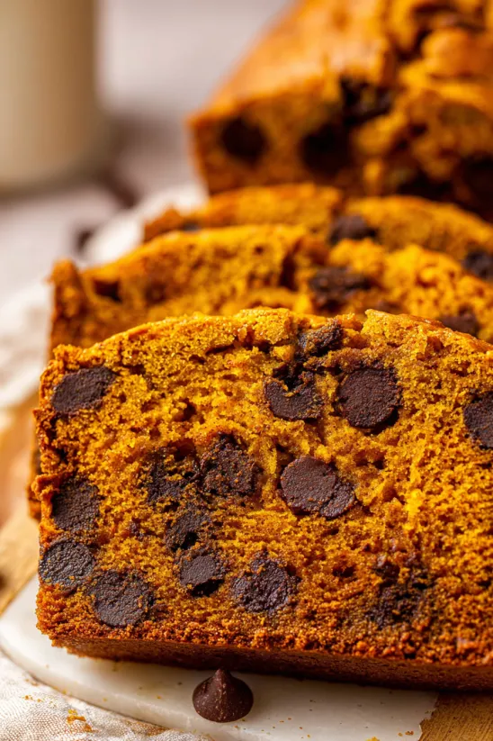 A slice of orange cake with chocolate chips.