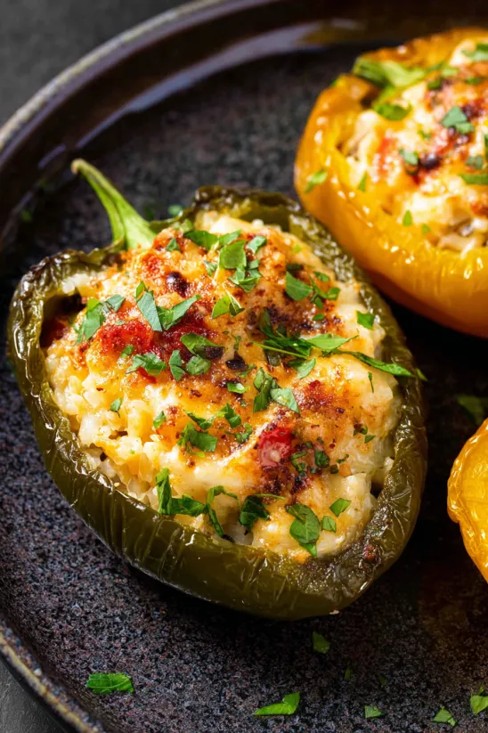 Two sliced peppers with cheese and herbs.