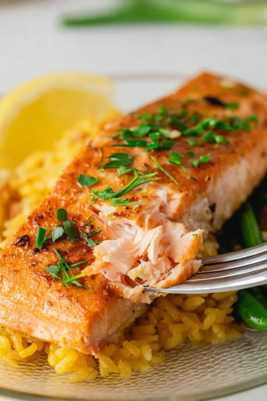 A piece of cooked salmon on a fork.