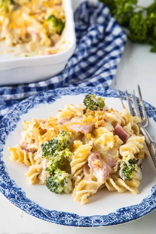 A plate of pasta with broccoli and ham.
