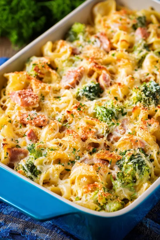 A dish of pasta with broccoli and ham.