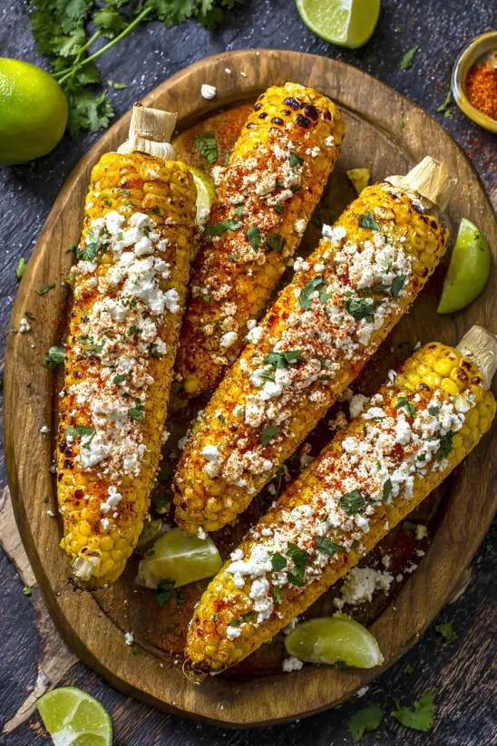 A plate of corn with cheese and lime.