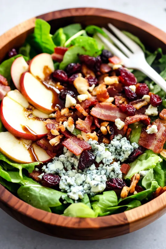 A salad with apples, bacon, and gorgonzola cheese.