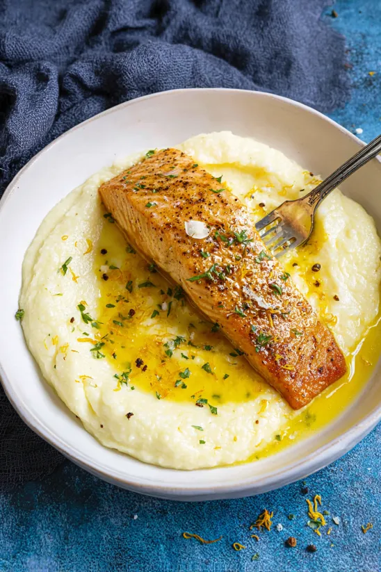 A plate of food with a grilled steelhead trout and chili-lime butter.