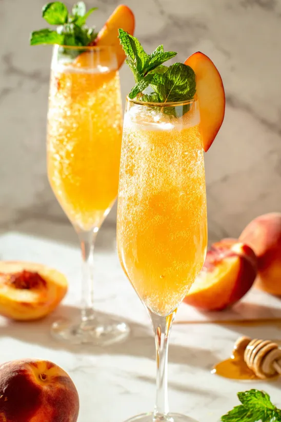 Two glasses of peach juice with mint leaves.