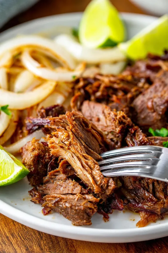 A fork is holding a piece of beef.