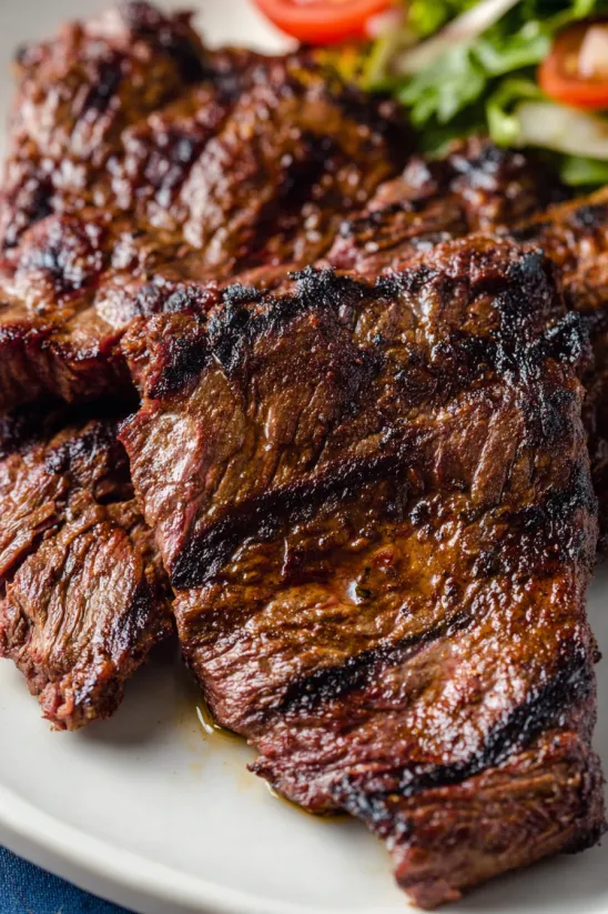 A piece of steak with a green garnish.
