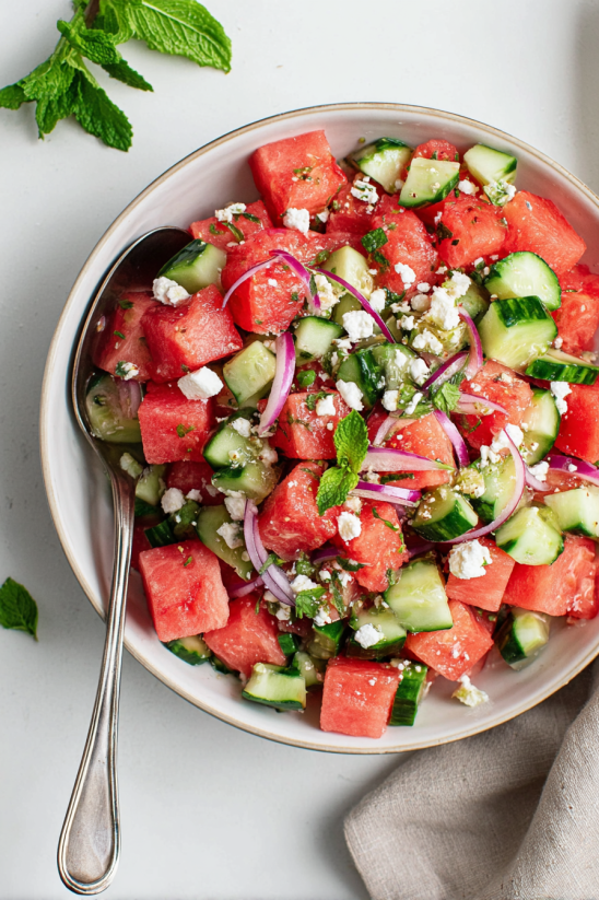 A bowl of watermelon salad with feta cheese and mint.