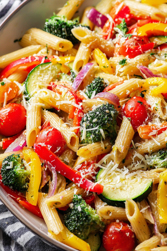 A dish of pasta primavera with various vegetables.