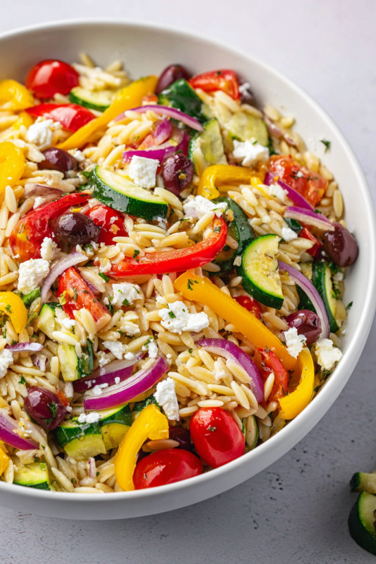 A bowl of rice, vegetables, and cheese.