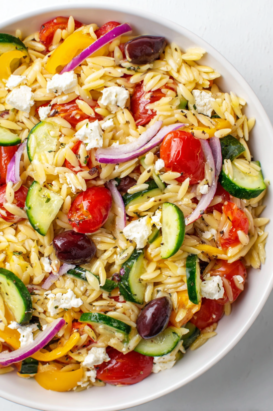 A bowl of rice with vegetables and cheese.