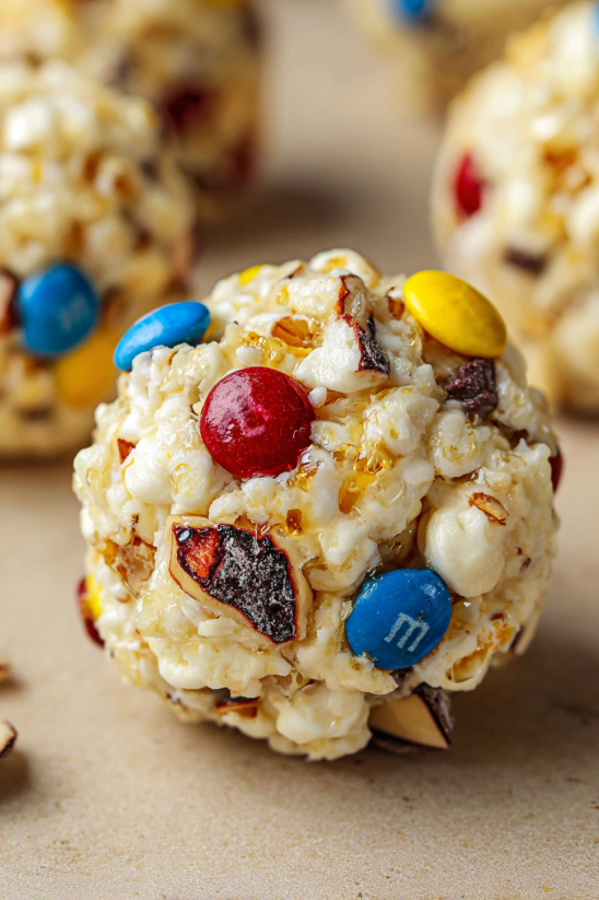 A candy ball with a marshmallow center and a chocolate drizzle.