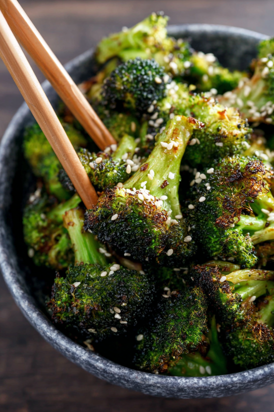 A bowl of broccoli with a wooden spoon in it.