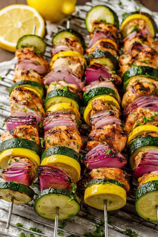 A plate of chicken skewers with vegetables.