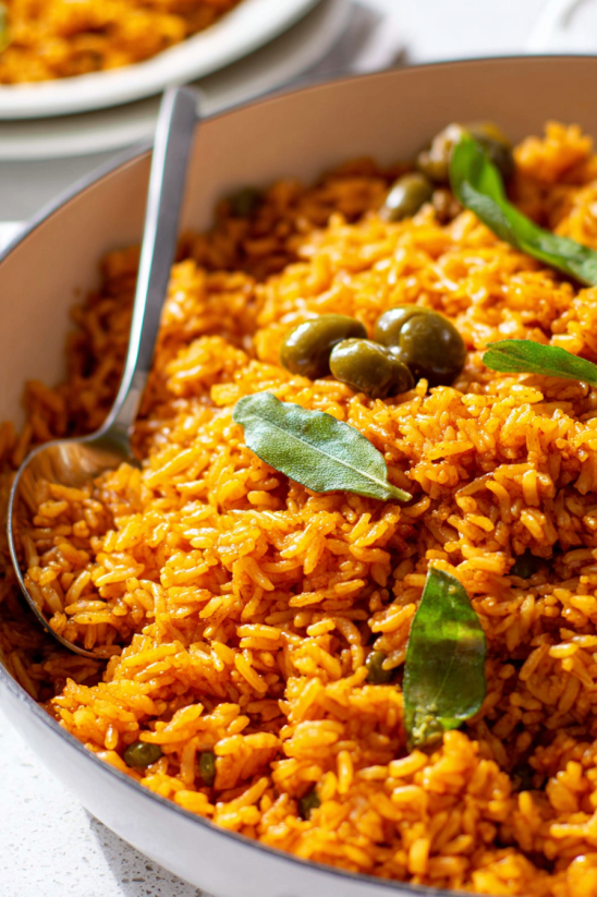 A bowl of rice with green leaves on top.