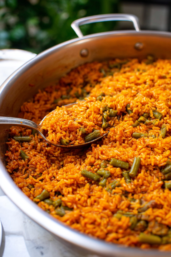 A spoon is in a bowl of rice and beans.