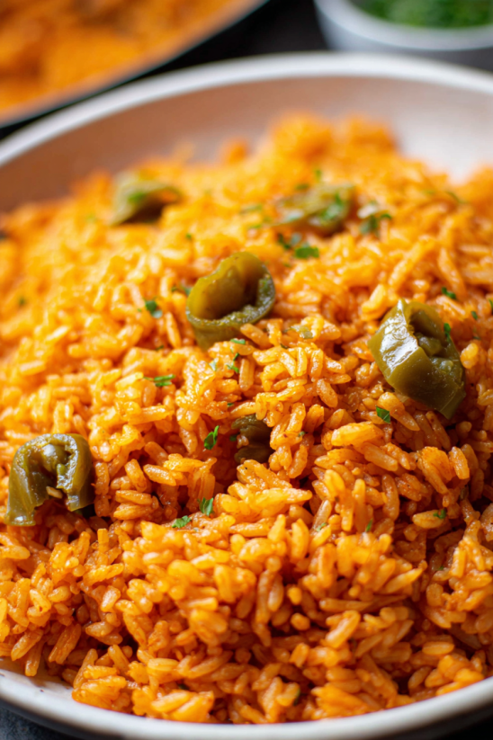 A bowl of rice with green peppers.