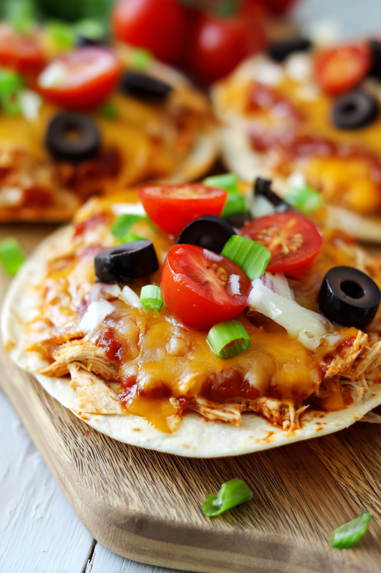 A pizza with olives, tomatoes, and cheese.