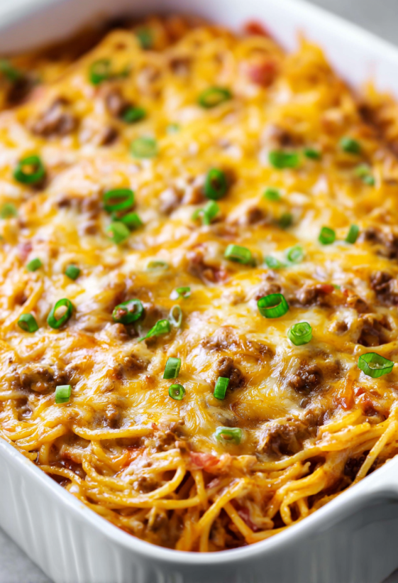 A dish of food with green onions on top.