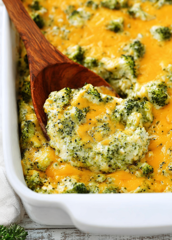 A wooden spoon in a bowl of broccoli.