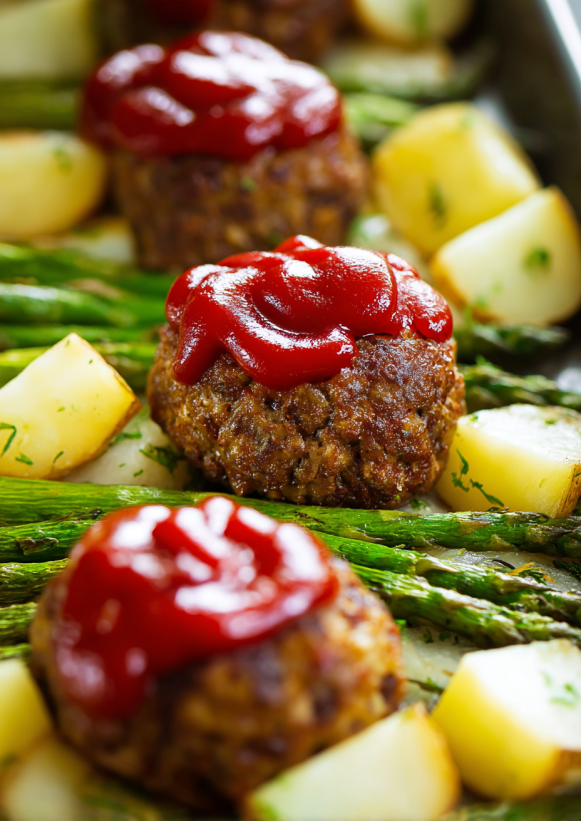 A meatloaf dinner with potatoes and asparagus.