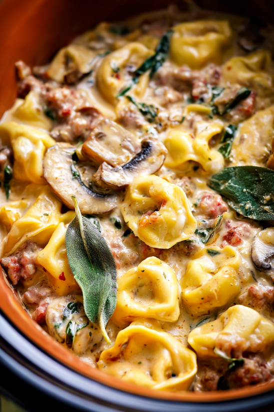 A bowl of pasta with mushrooms and spinach.