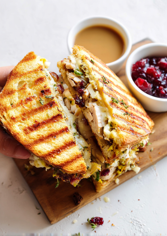 A sandwich with a cup of jelly.