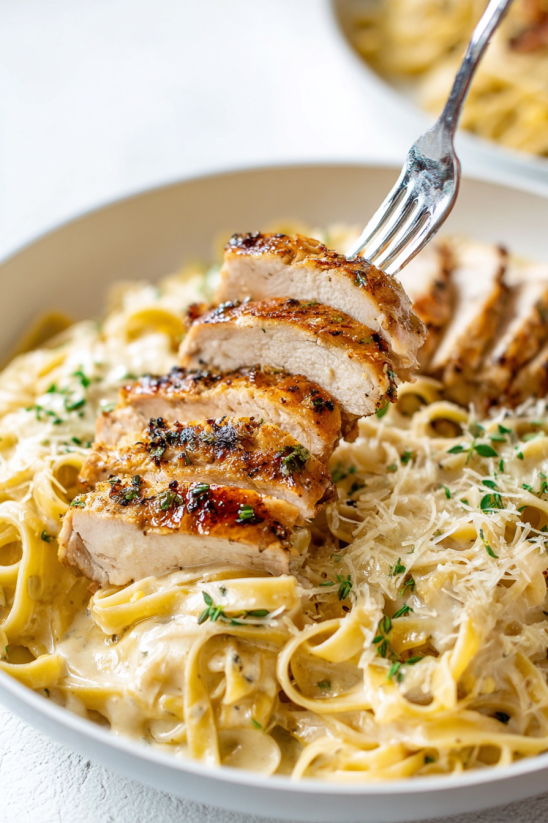 A fork is holding a piece of chicken.