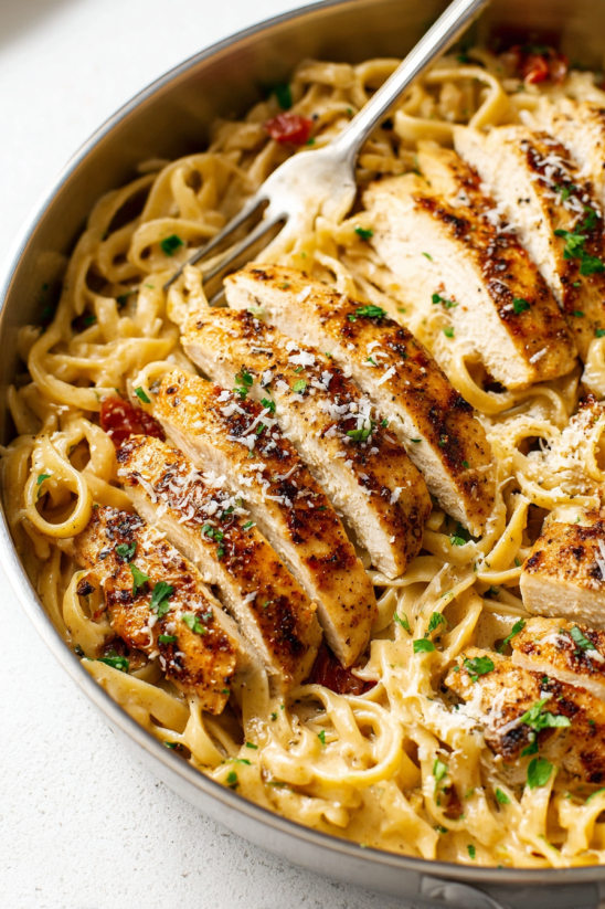 A bowl of pasta with chicken and cheese.
