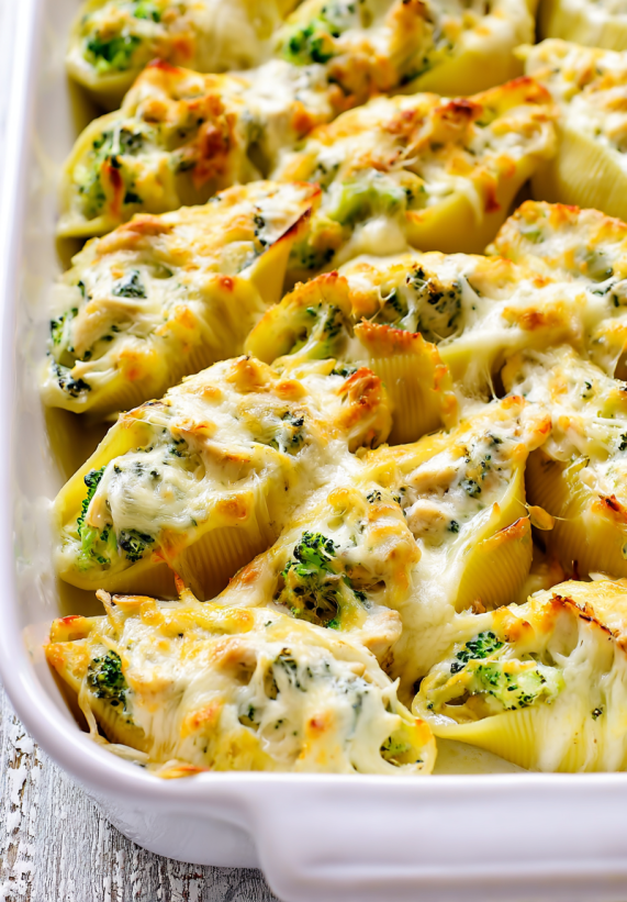A dish of chicken and broccoli alfredo stuffed shells.