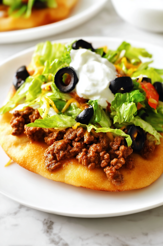 A plate of food with lettuce, tomatoes, olives, and cheese.