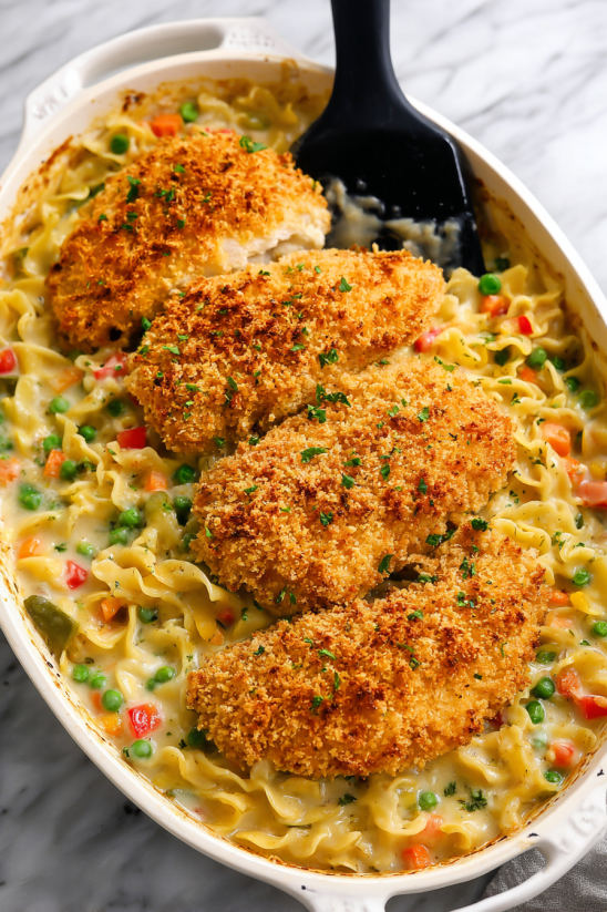 A bowl of pasta with chicken and peas.