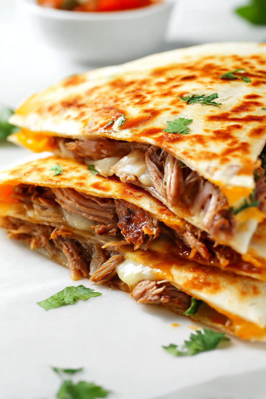 A stack of beef enchiladas on a plate.