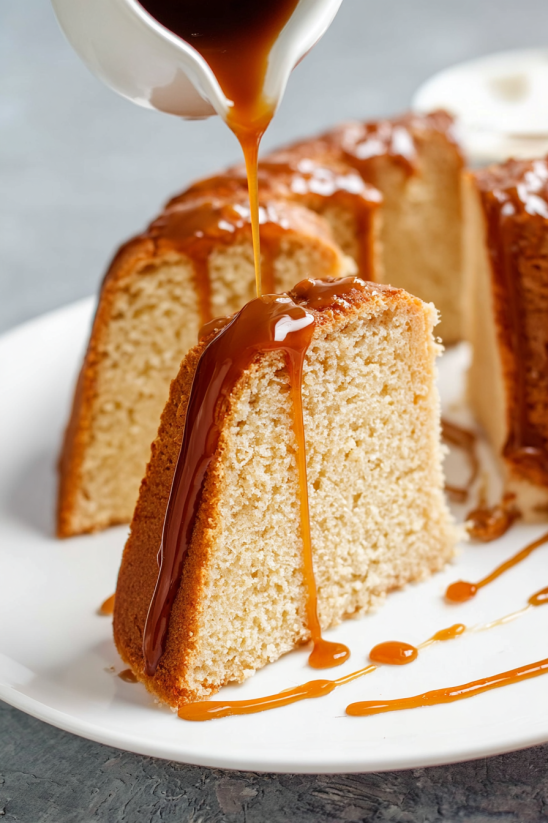A slice of cake with syrup drizzled on it.