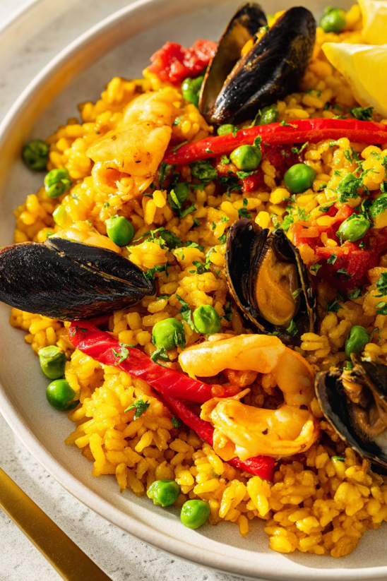 A plate of food with rice, peas, and shrimp.