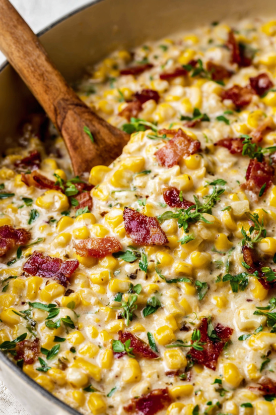 A bowl of creamed corn with bacon bits.