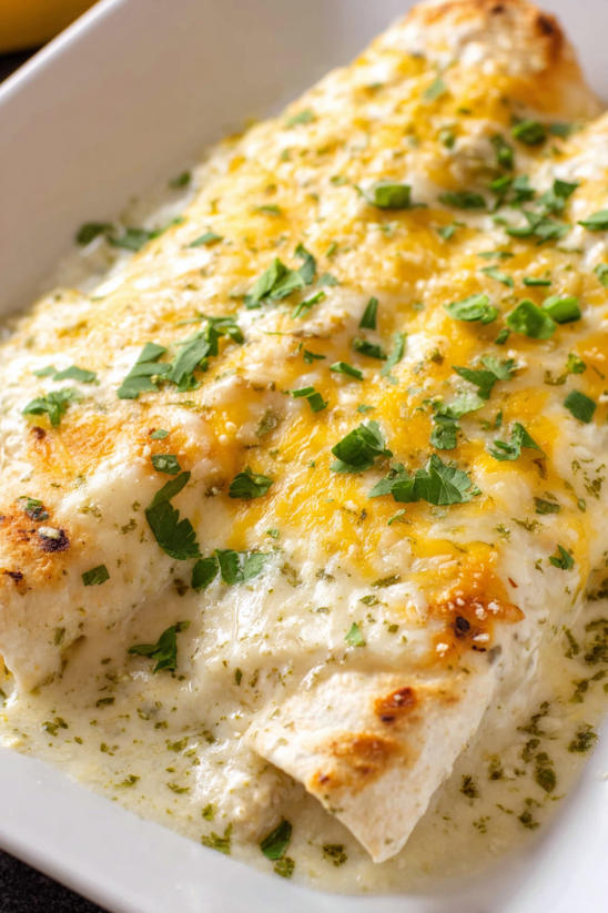 Sour cream chicken enchiladas with green herbs.