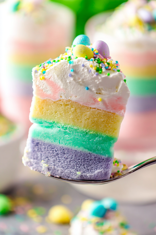 A slice of rainbow cake with sprinkles.