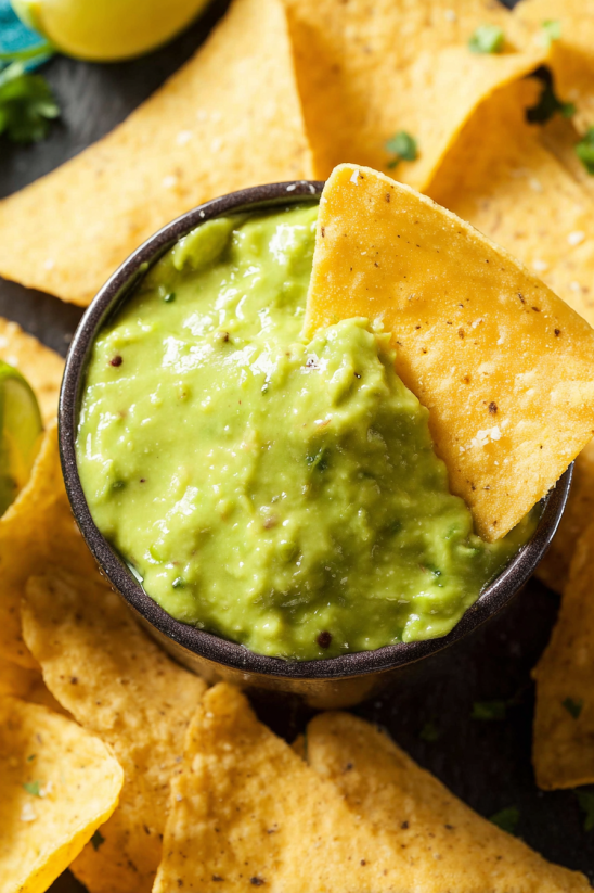 A bowl of avocado salsa with chips.