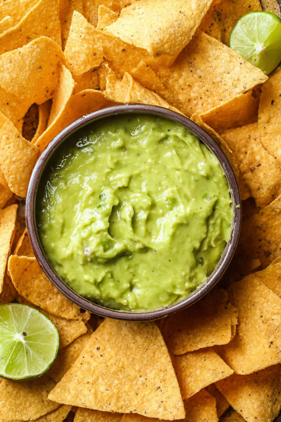 A bowl of guacamole sits on a table.