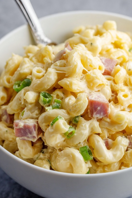 A bowl of macaroni salad with ham.