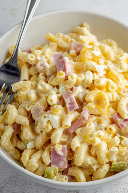 A bowl of macaroni and cheese with ham.
