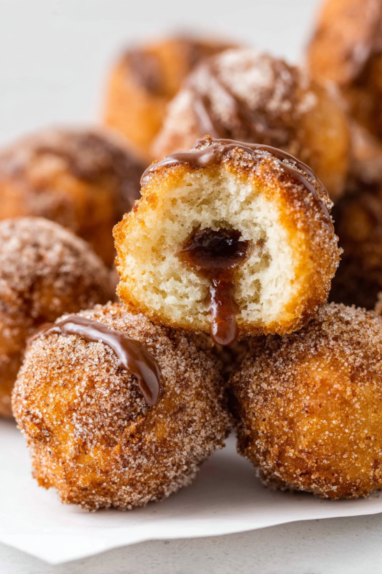 A close up of a donut with chocolate drizzled on it.