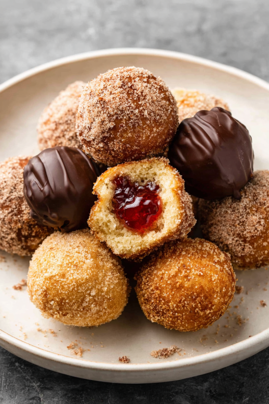A plate of doughnuts with jelly and chocolate.